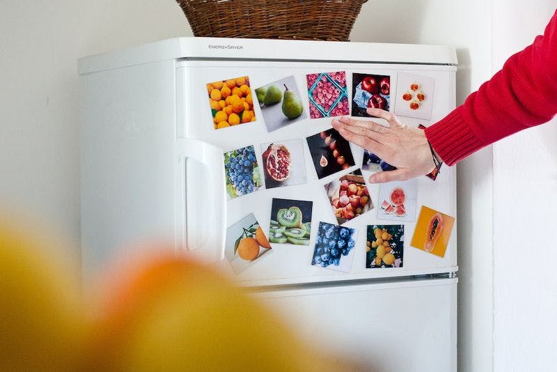 fridge with magnet photos of fruit