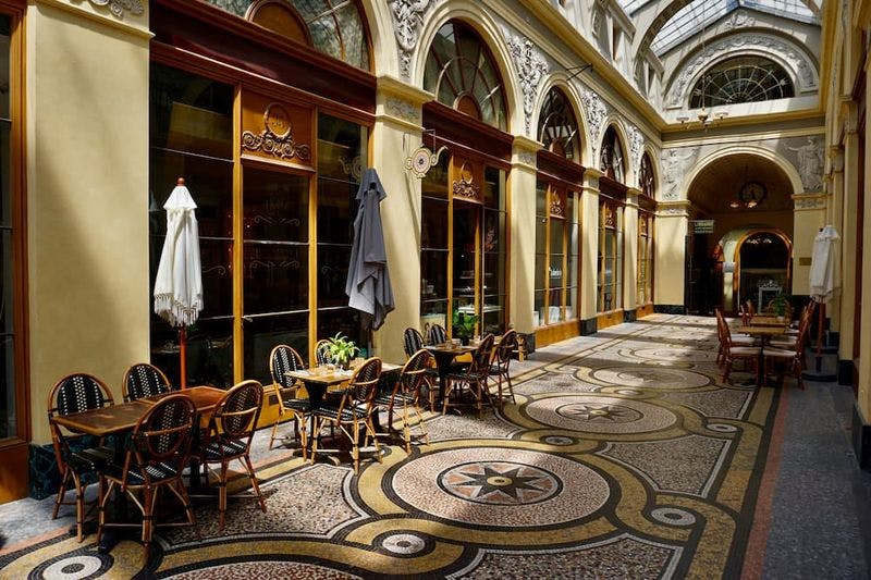 Tiled floors and tables under a sun roof in the paris passages