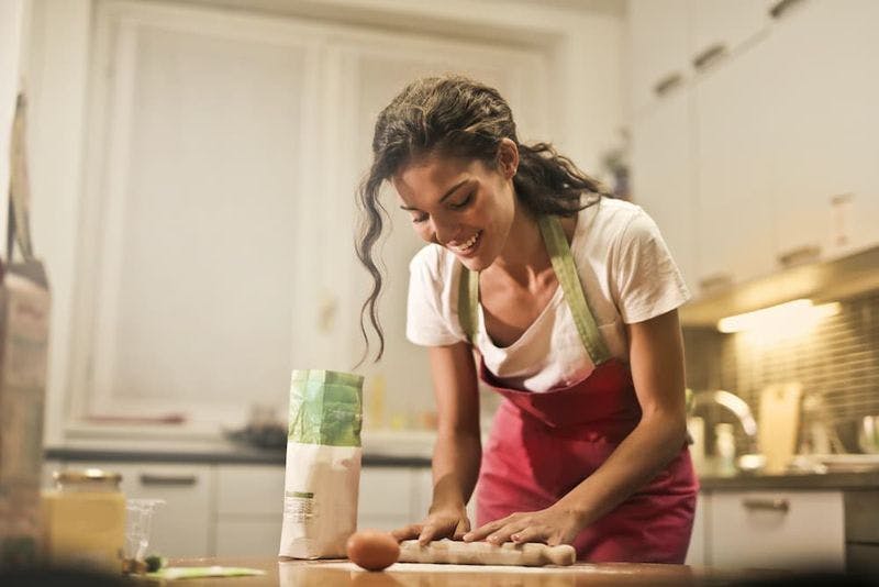 Woman rolling out dough in a kitchen