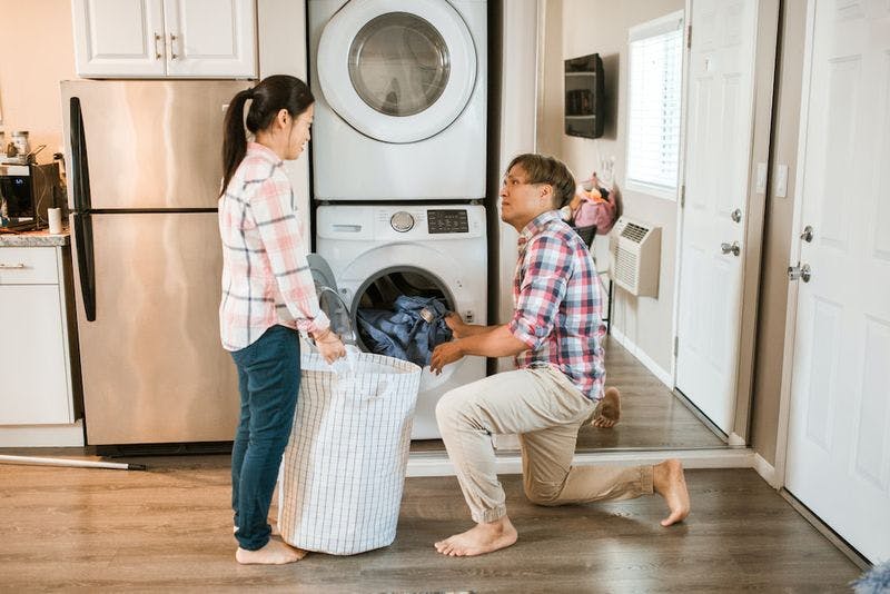 couple putting laundry in machine