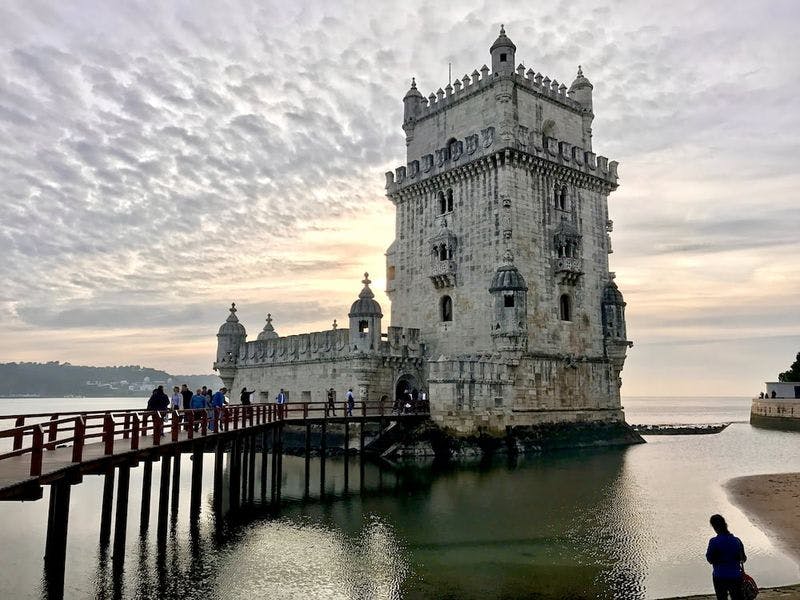 udbelem tower in the water with dramatic clouds behind